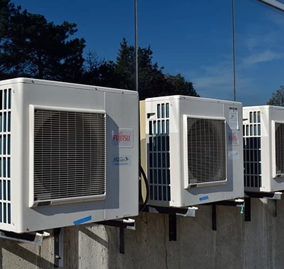 A row of wall-mounted air conditioning condenser units A row of wall-mounted air conditioning condenser units